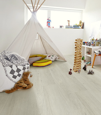 un sol vinyle gris dans une chambre d’enfant pleine de jouets
